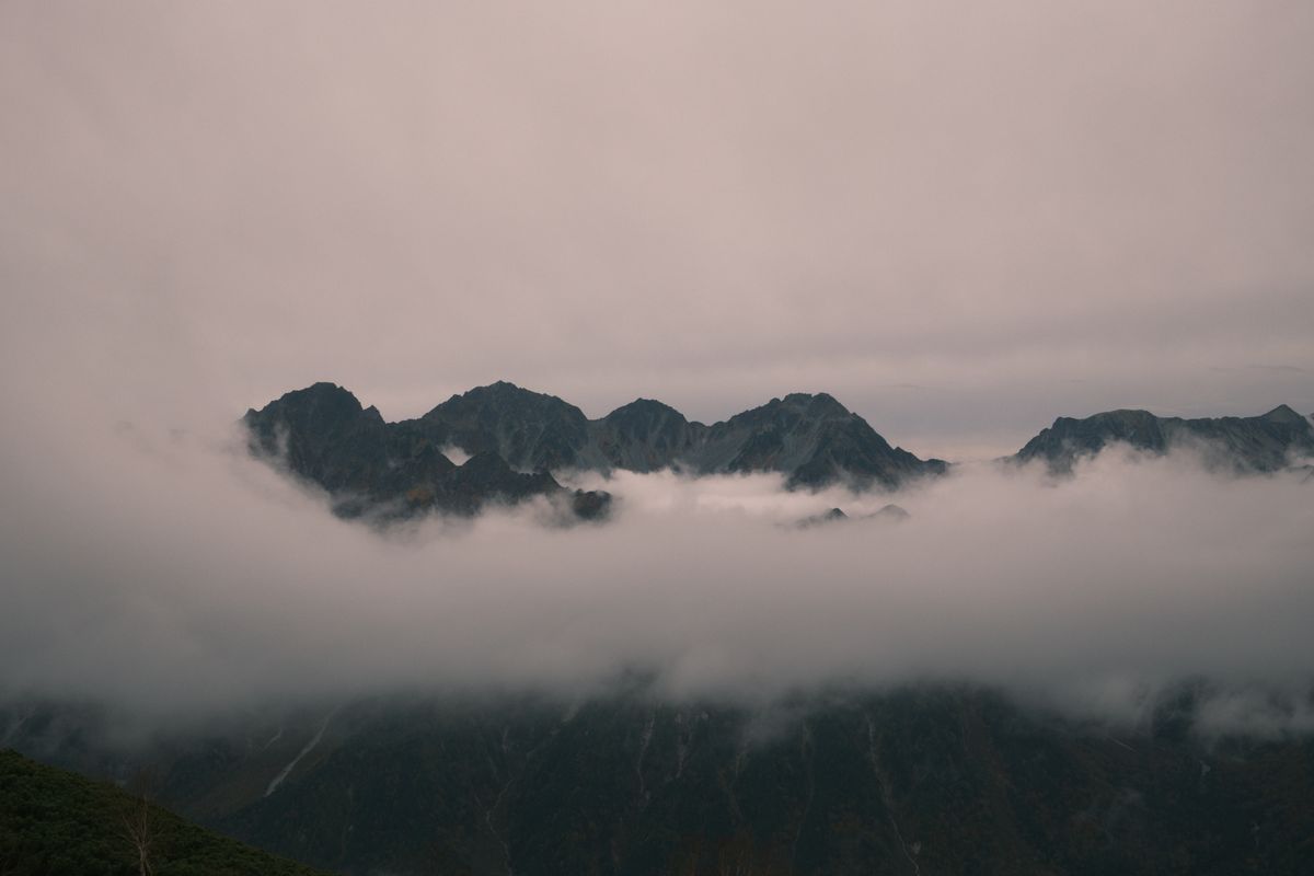 Misty volcanic mountain peaks rising above the clouds, similar to the Kirishima range and Ebino Plateau