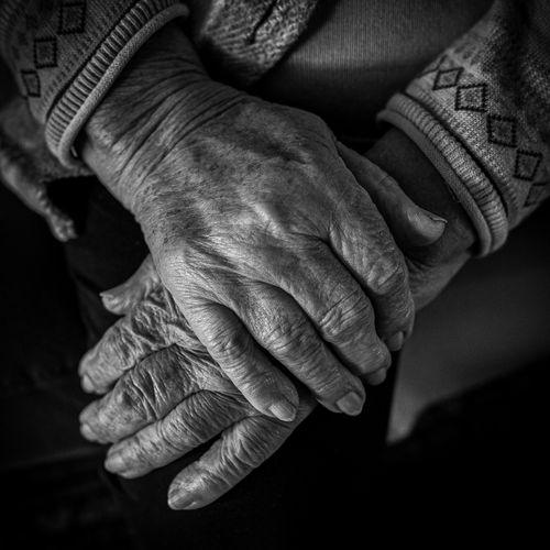 Free Detailed black and white photo capturing the texture of elderly hands folded gently. Stock Photo