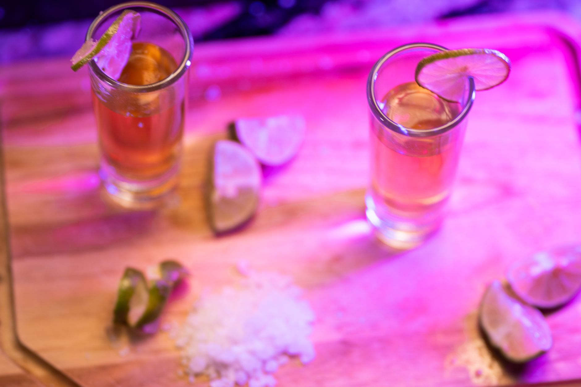 Cheers with mezcal shots, some bottles featuring worms inside
