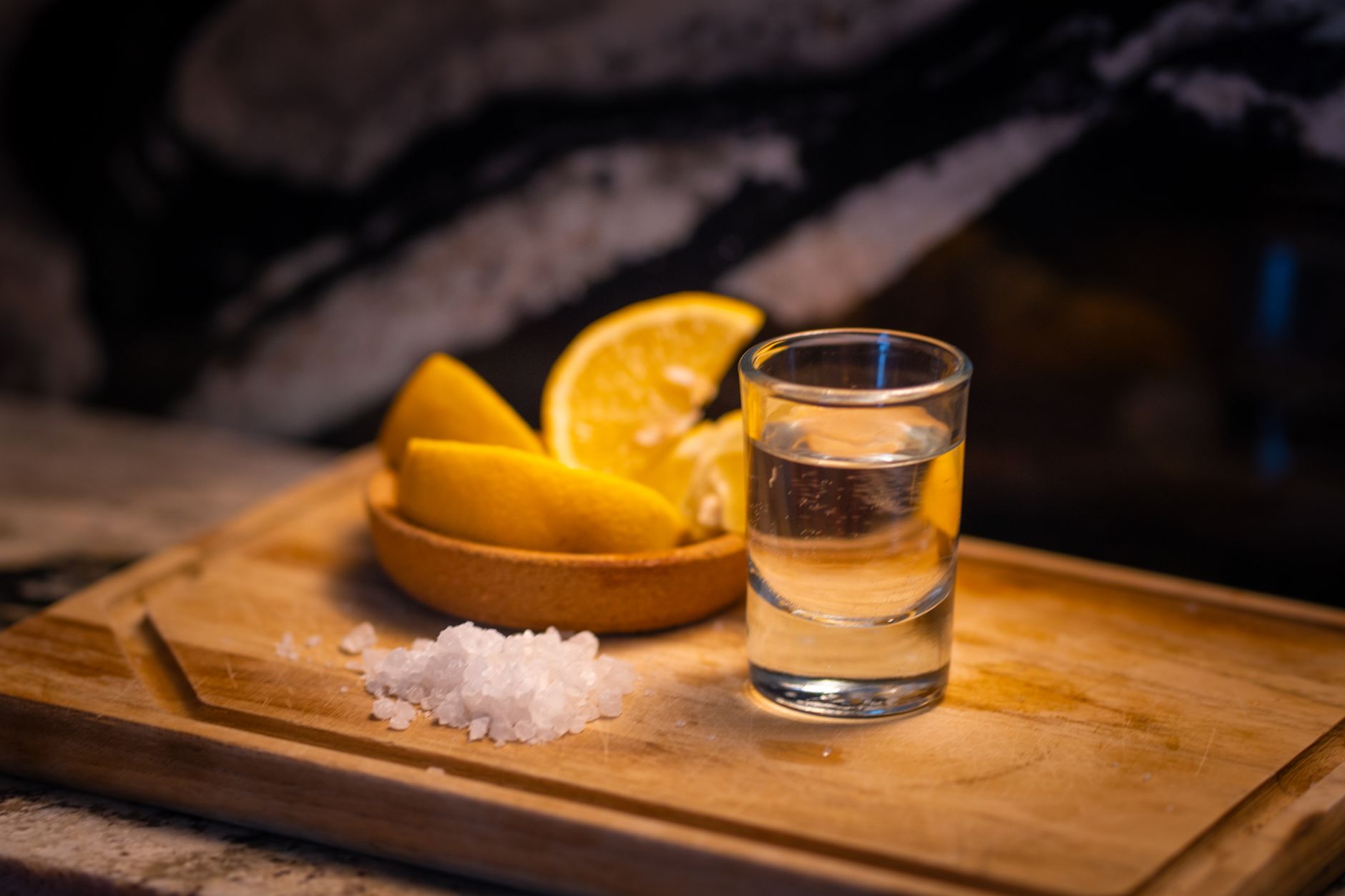 Pouring tequila into a glass with salt and lime