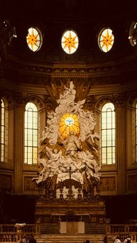 Majestic baroque altar with intricate sculptures and stained glass in a historic church.