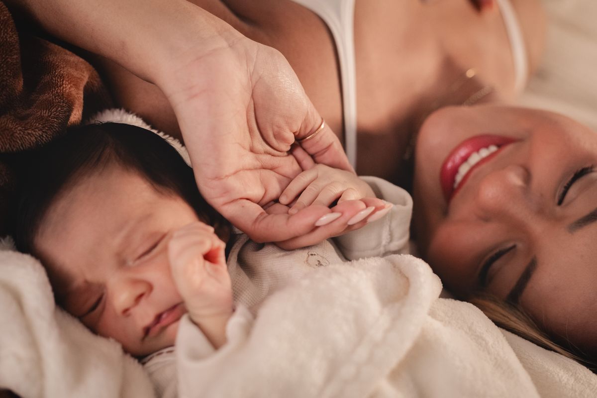 Madre y recién nacido cogiéndose de las manos