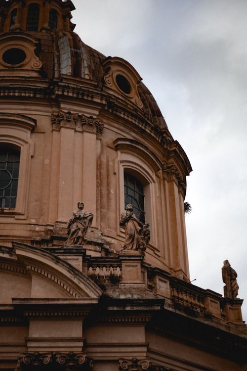 Free Close-up of ornate baroque architecture with stone sculptures under a cloudy sky. Stock Photo