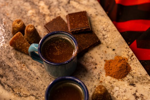 Traditional Mexican café de olla with cinnamon and piloncillo on a marble countertop.