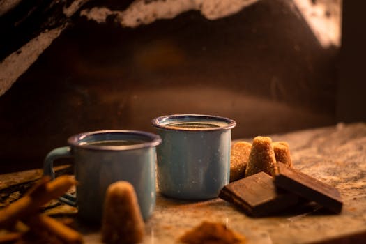 Traditional Mexican cafe de olla with cinnamon and piloncillo in blue enamel mugs.