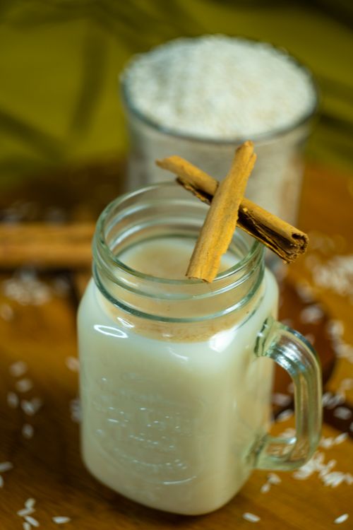Free Delicious traditional Mexican horchata served in a mason jar with cinnamon sticks, perfect for refreshing. Stock Photo
