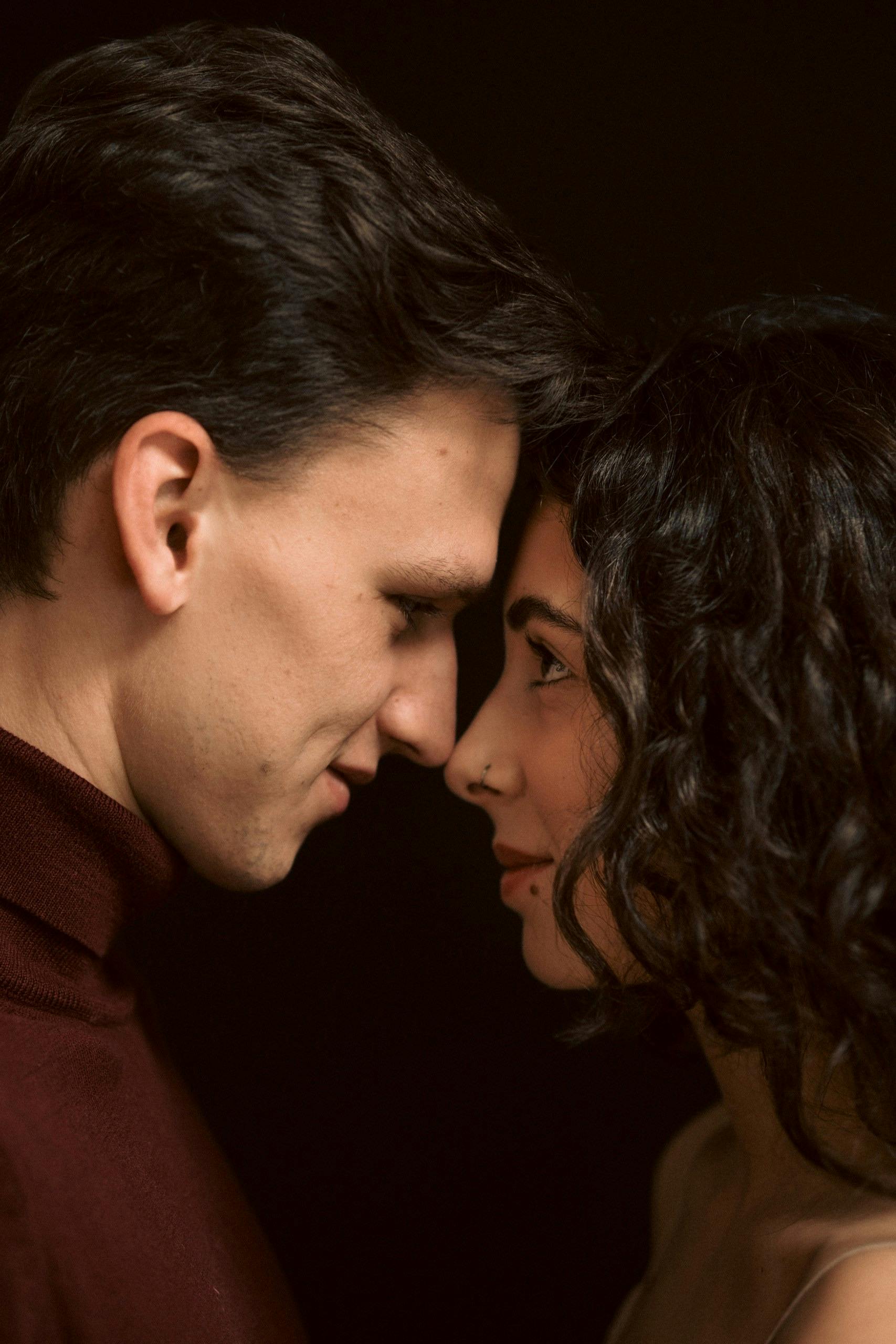 Intimate couple faces close, whispering in soft warm light, deep connection moment