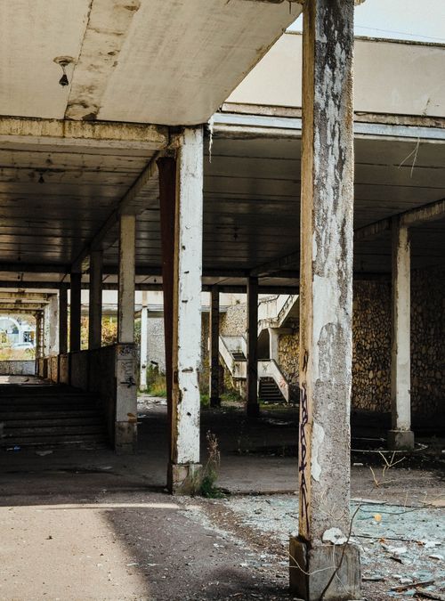 Free Urban decay scene of a deserted building with damaged pillars and peeling paint. Stock Photo