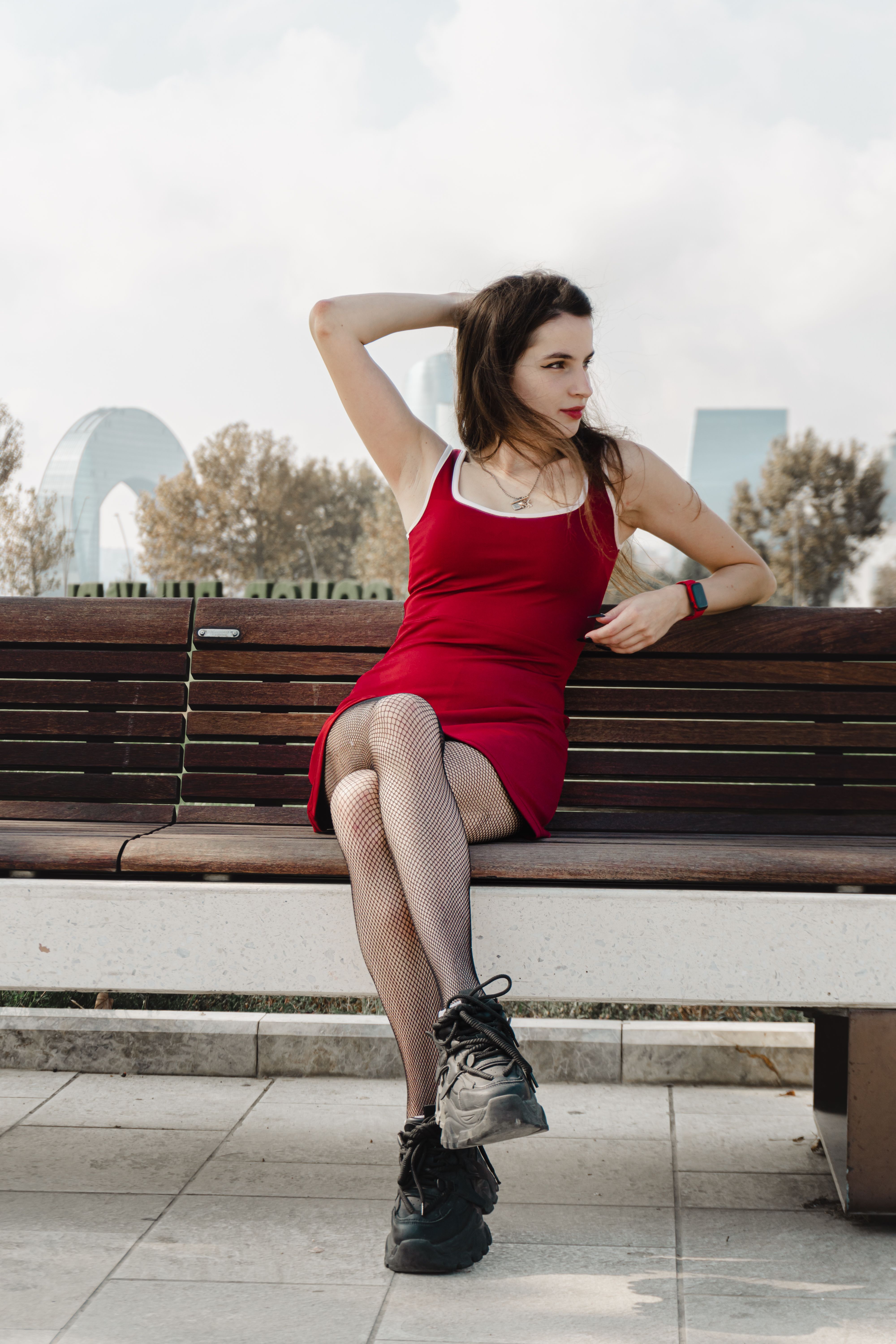 Stylish Woman in Red Dress Sitting on a Bench · Free Stock Photo