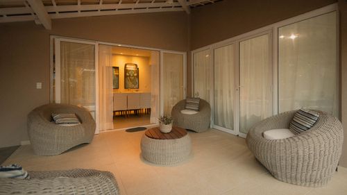 Free A stylish outdoor patio with wicker chairs and ambient lighting, perfect for relaxation. Stock Photo