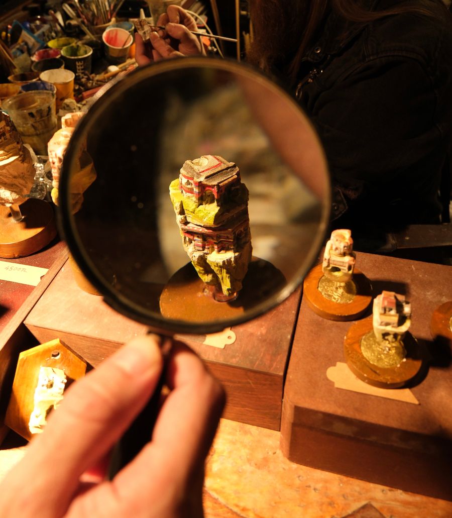 A cast part inspected under a magnifier at the checking bench