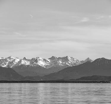 Stunning black and white photograph of Lake Starnberg with the Bavarian Alps in the background.