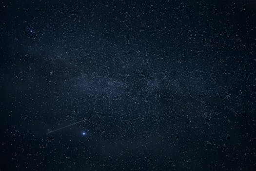 Clear night sky with countless stars and a visible shooting star.