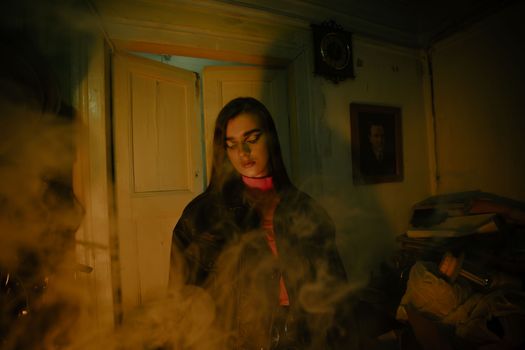 Artistic portrait of a woman surrounded by smoke in a dimly lit vintage room.
