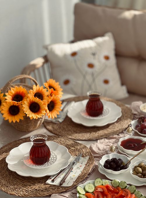 Free Cozy table setting with sunflowers, tea, and a variety of fruits. Stock Photo