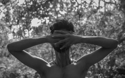 Fotografia Em Tons De Cinza De Um Homem De Topless Em Pé Enquanto Cobre O Rosto