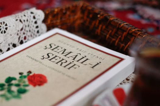 Close-up of the Semail-i Serif book with a woven basket and lace in the background.