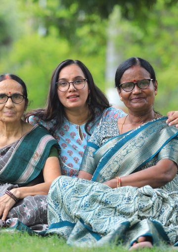 Three generations of women sitting together in a green park