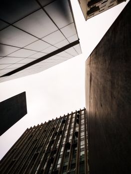 从低角度拍摄现代摩天大楼，以明亮的天空为背景，捕捉城市建筑的景象
