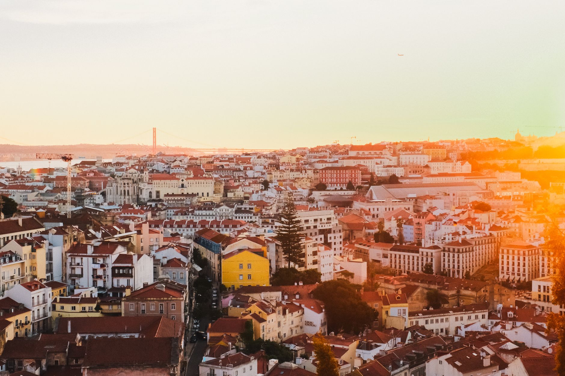 A breathtaking view of Lisbon's historic cityscape with vibrant rooftops at sunset.