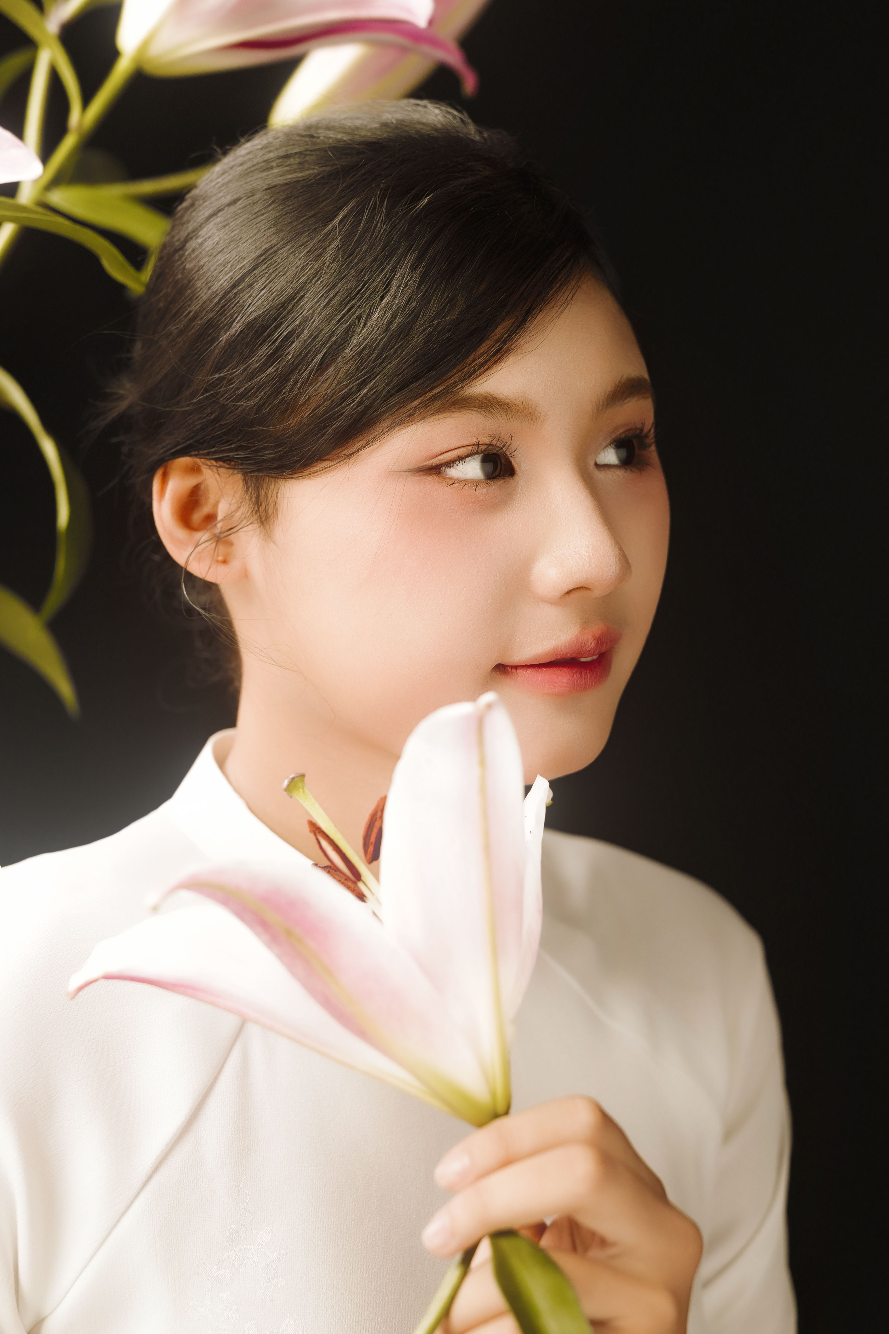 Portrait of a woman with a lily flower, exuding elegance and grace.