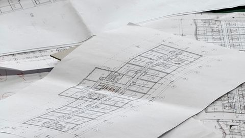 Close-up of detailed architectural blueprints spread out on a desk.