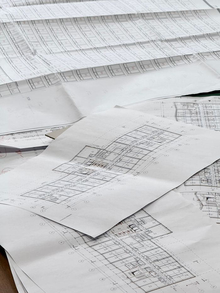 Detailed architectural blueprints spread across a desk