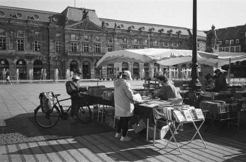 Free A bustling outdoor market in Strasbourg, France with historic architecture in the background. Stock Photo