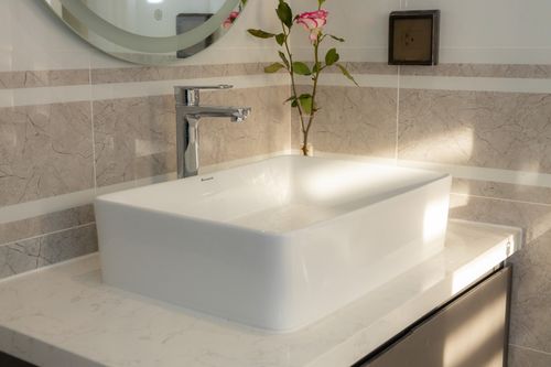 Free Elegant white sink in a modern bathroom with a pink rose decoration. Minimalist design with a touch of nature. Stock Photo