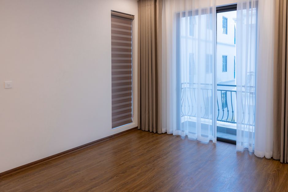 Bright modern room with wooden floor and large windows, ideal for real estate or interior design inspiration.