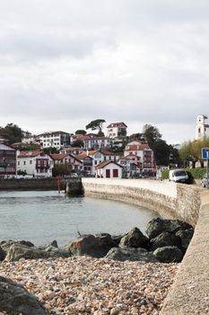 Scenic view of a charming French coastal village with white buildings by the sea.