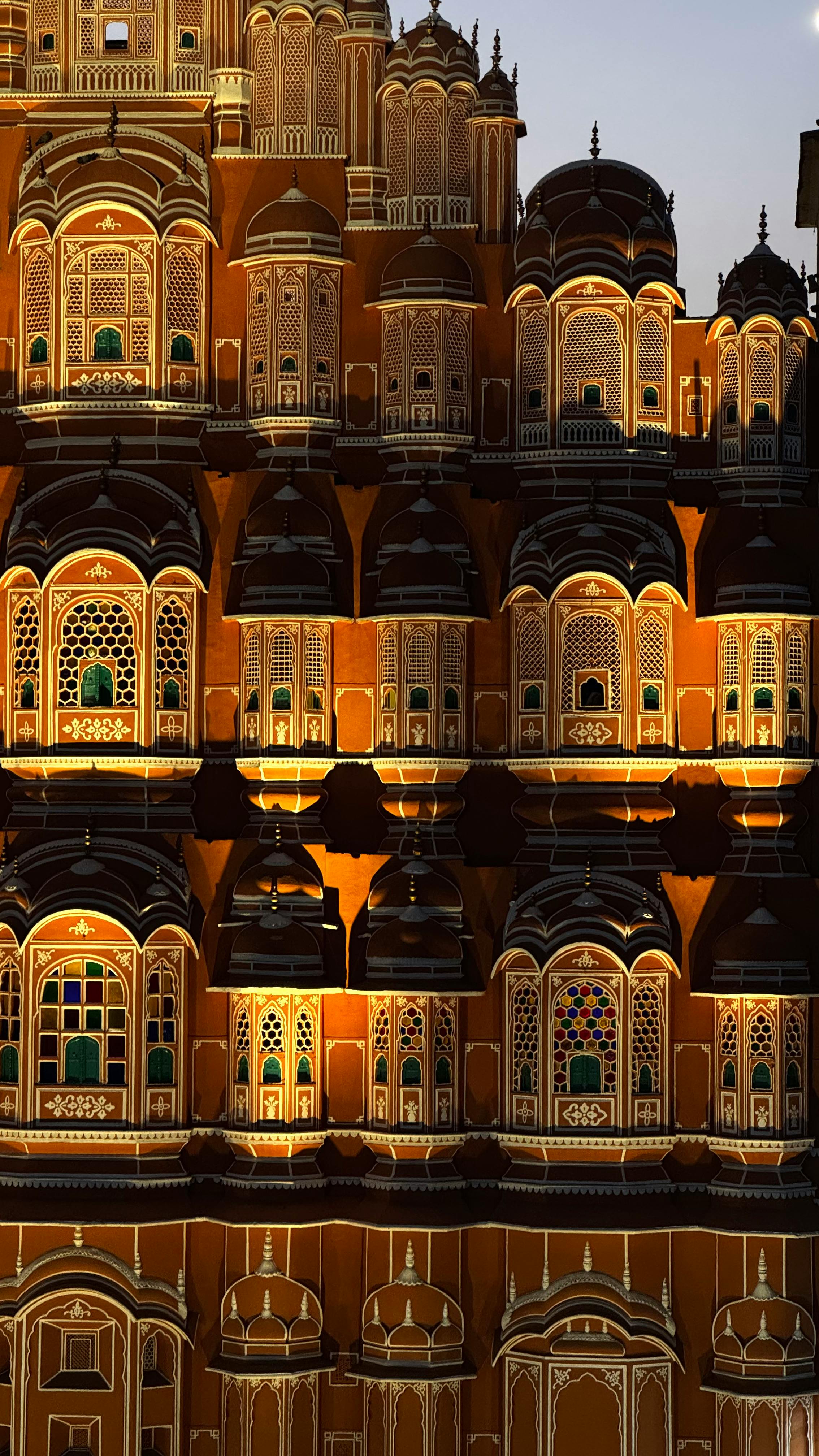 Detailed view of Hawa Mahal's intricate facade illuminated at twilight in Jaipur, India.