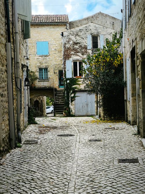 Free Explore the quaint charm of a cobblestone alley nestled in a historic European village with rustic architecture. Stock Photo