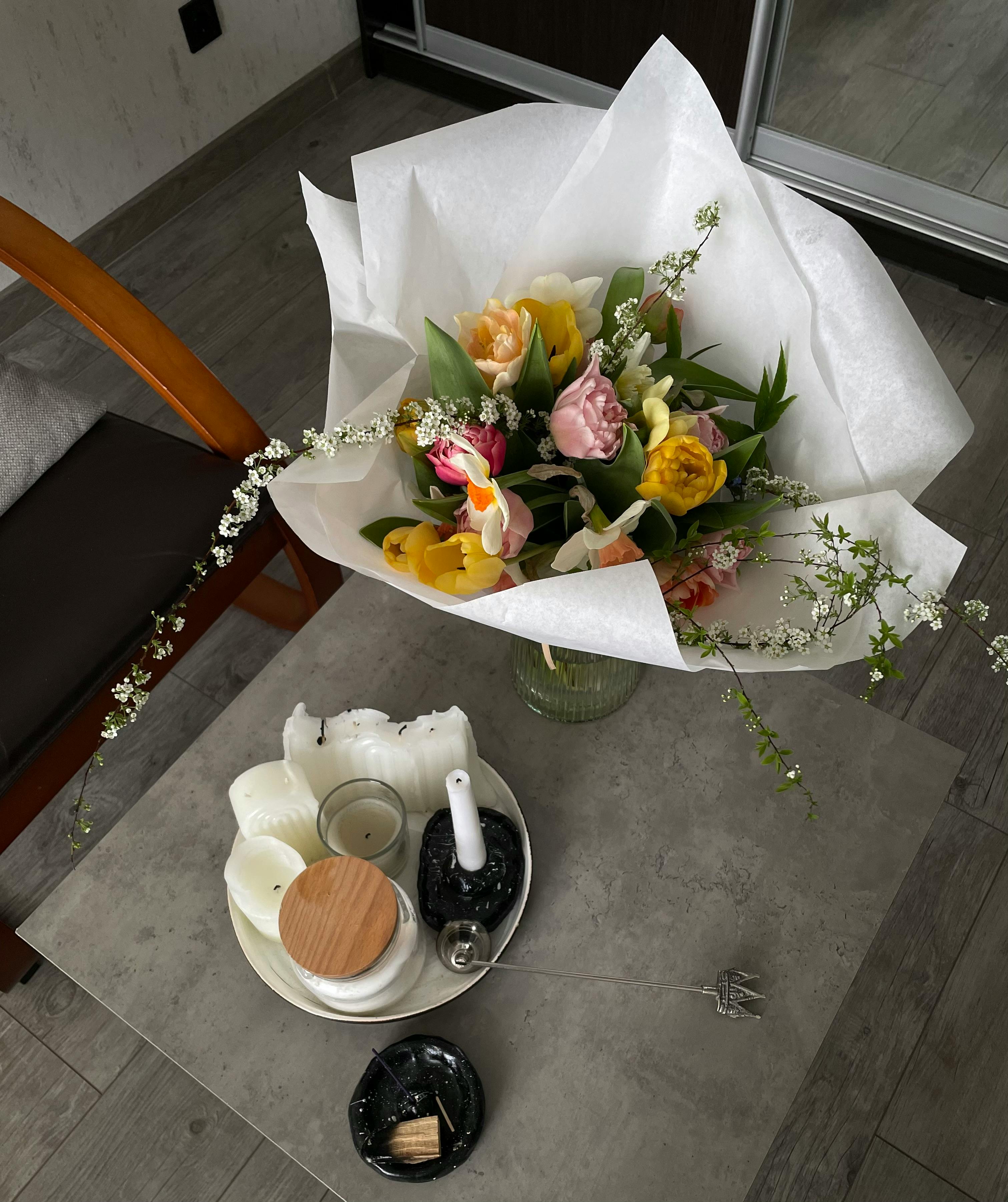Beautiful bouquet of flowers on a coffee table with candles, creating a cozy indoor ambiance.