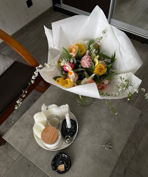 Beautiful bouquet of flowers on a coffee table with candles, creating a cozy indoor ambiance.