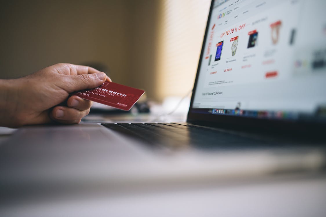 Image of Black and Gray Laptop Computer With Turned-on Screen Beside Person Holding Red Smart Card in Selective-focus Photography