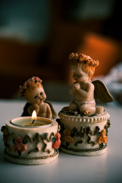 Free Charming angel figurine and candle setup creating a warm, decorative ambiance. Stock Photo