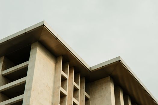 Abstract view of a minimalist architectural building with clean lines against a cloudy sky.