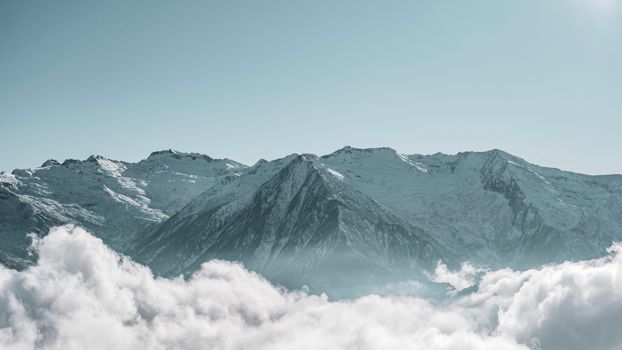 Stunning snow-capped mountains rising above clouds in Arılı, Artvin, Türkiye.