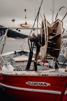 Rustic red fishing boat docked in Le Pradet Harbor, Provence, France.