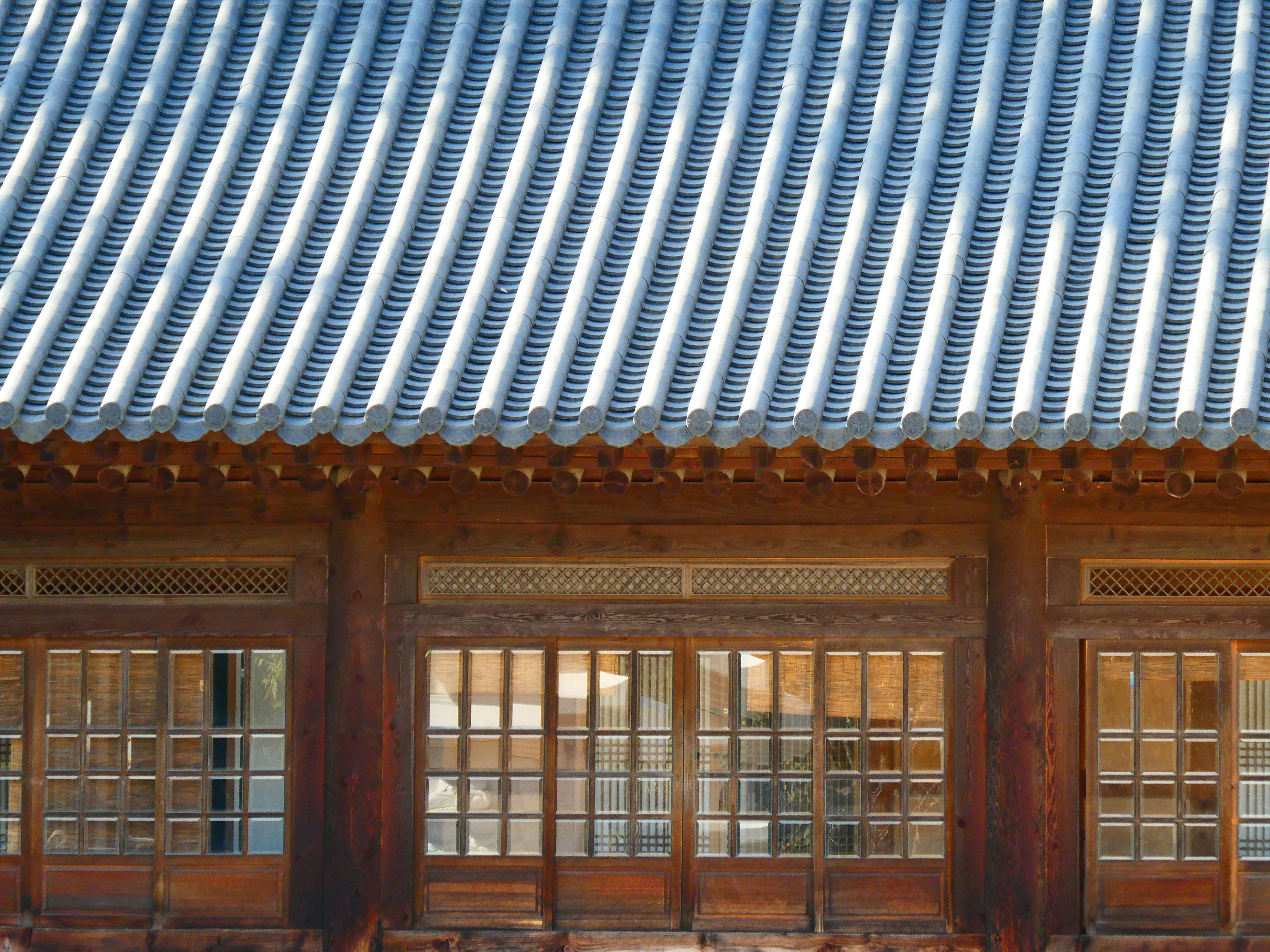 Close-up of a traditional Korean building with a tiled roof and wooden lattice windows.
