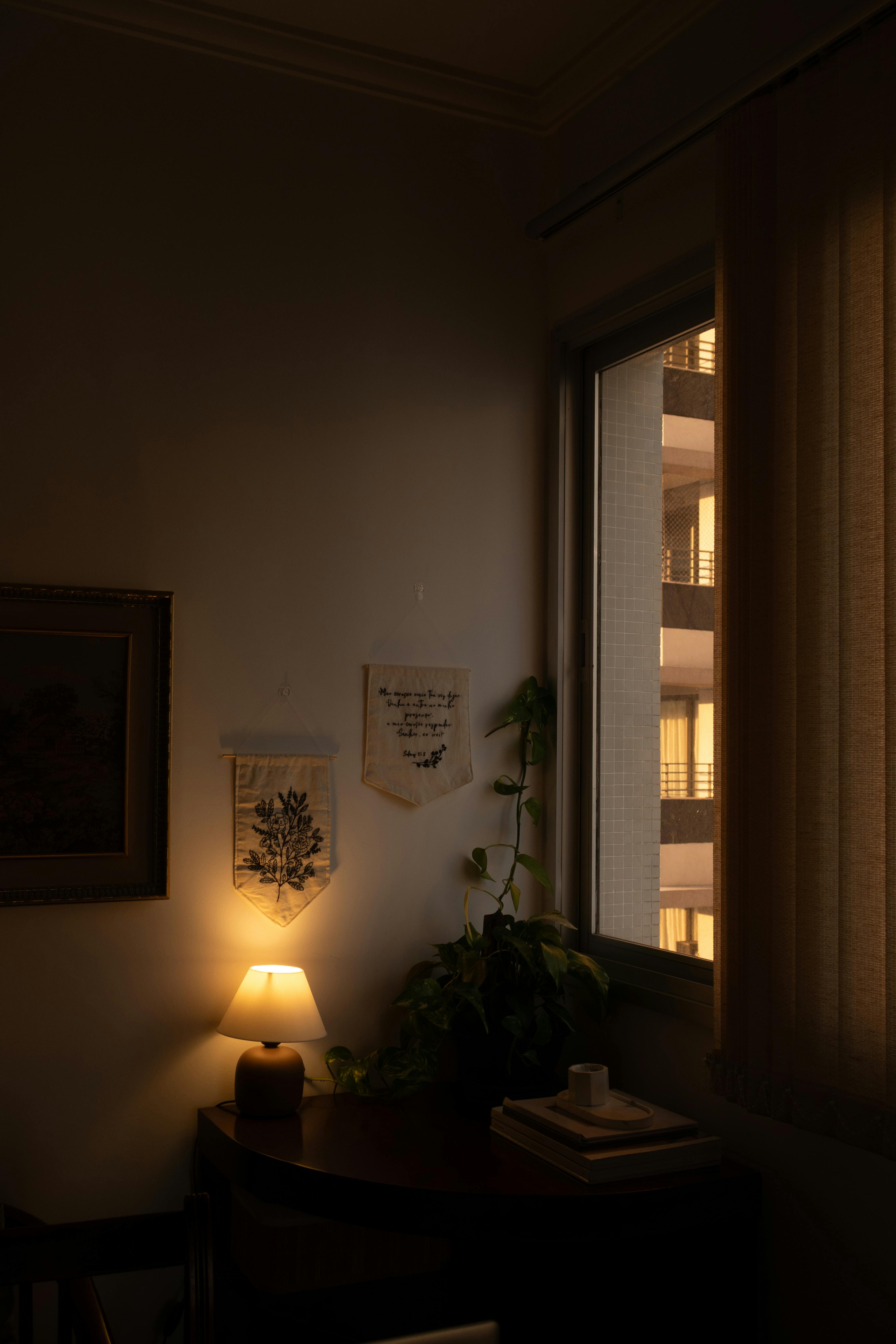 A cozy indoor corner with warm ambient lighting and a city view at night, ideal for relaxation.