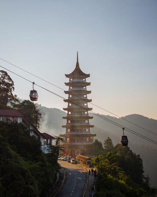 Majestic pagoda in Genting Highlands, Malaysia with surrounding cable cars and lush greenery.