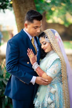 A beautiful couple in traditional attire, standing elegantly outdoors.