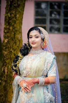 Stunning Asian woman in traditional wedding attire with intricate jewelry and henna designs.