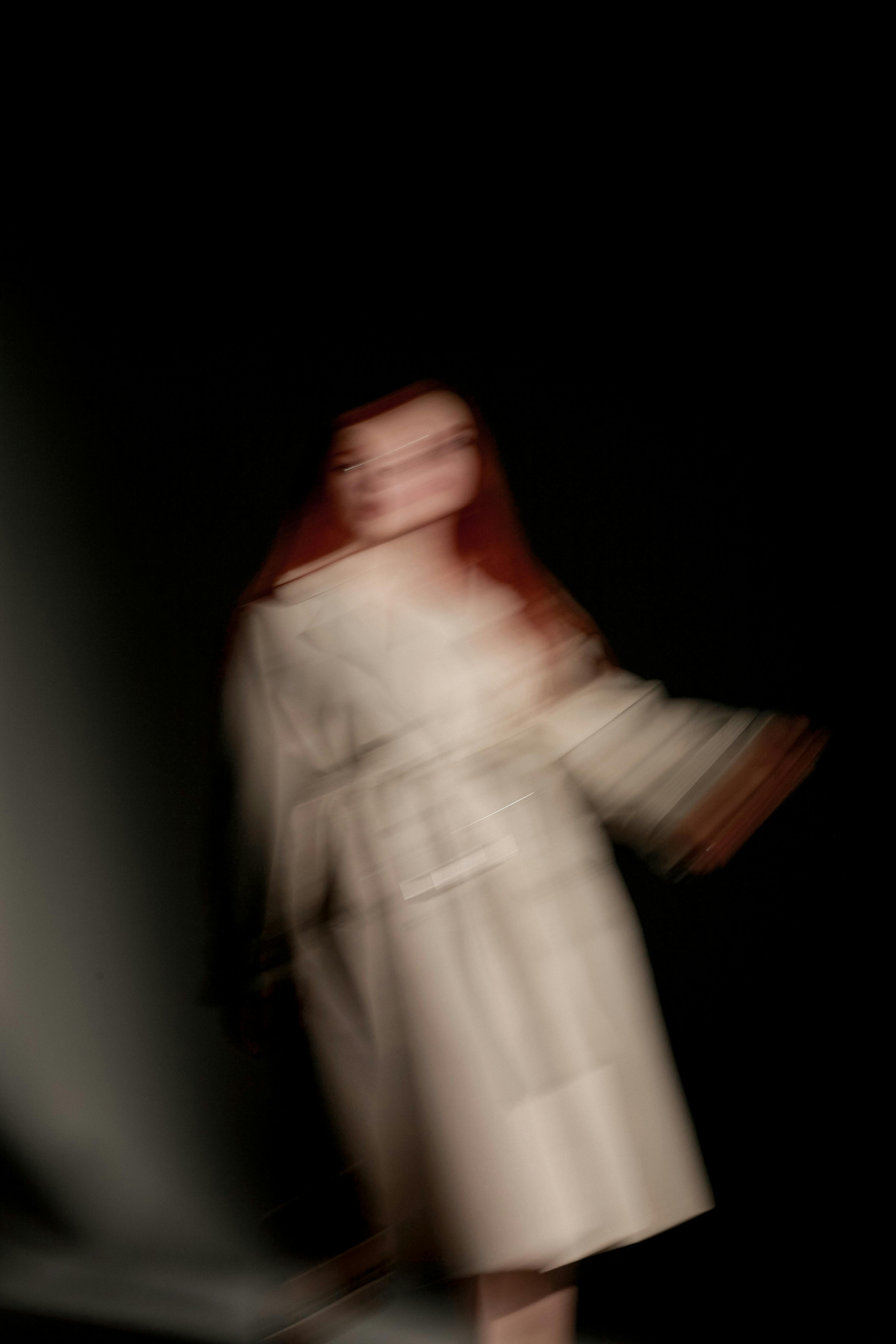 Kostnadsfria Suddig konstnärlig rörelsefångst av kvinna i beige kappa, minimalistisk stil. Stock foto