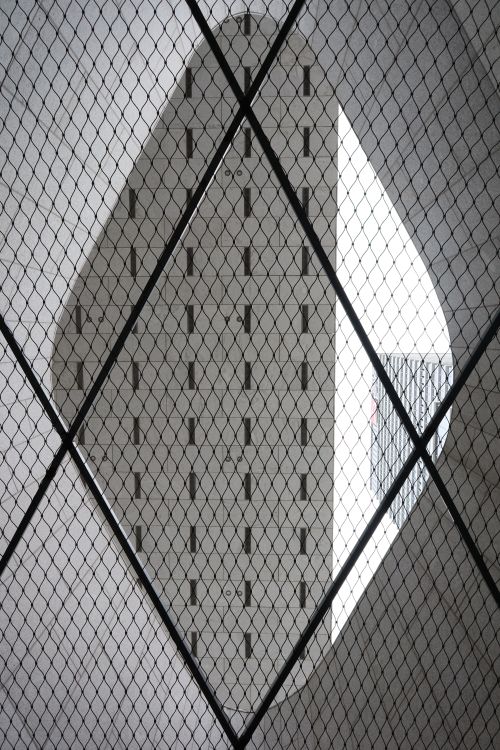 Free Urban architecture captured through a diamond-shaped mesh, creating an artistic perspective. Stock Photo