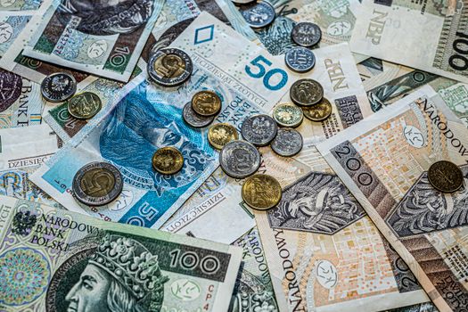 Close-up of Polish złoty currency, including various banknotes and coins scattered.