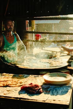 A street vendor in Chilmari, Bangladesh prepares parathas under the morning sun.
