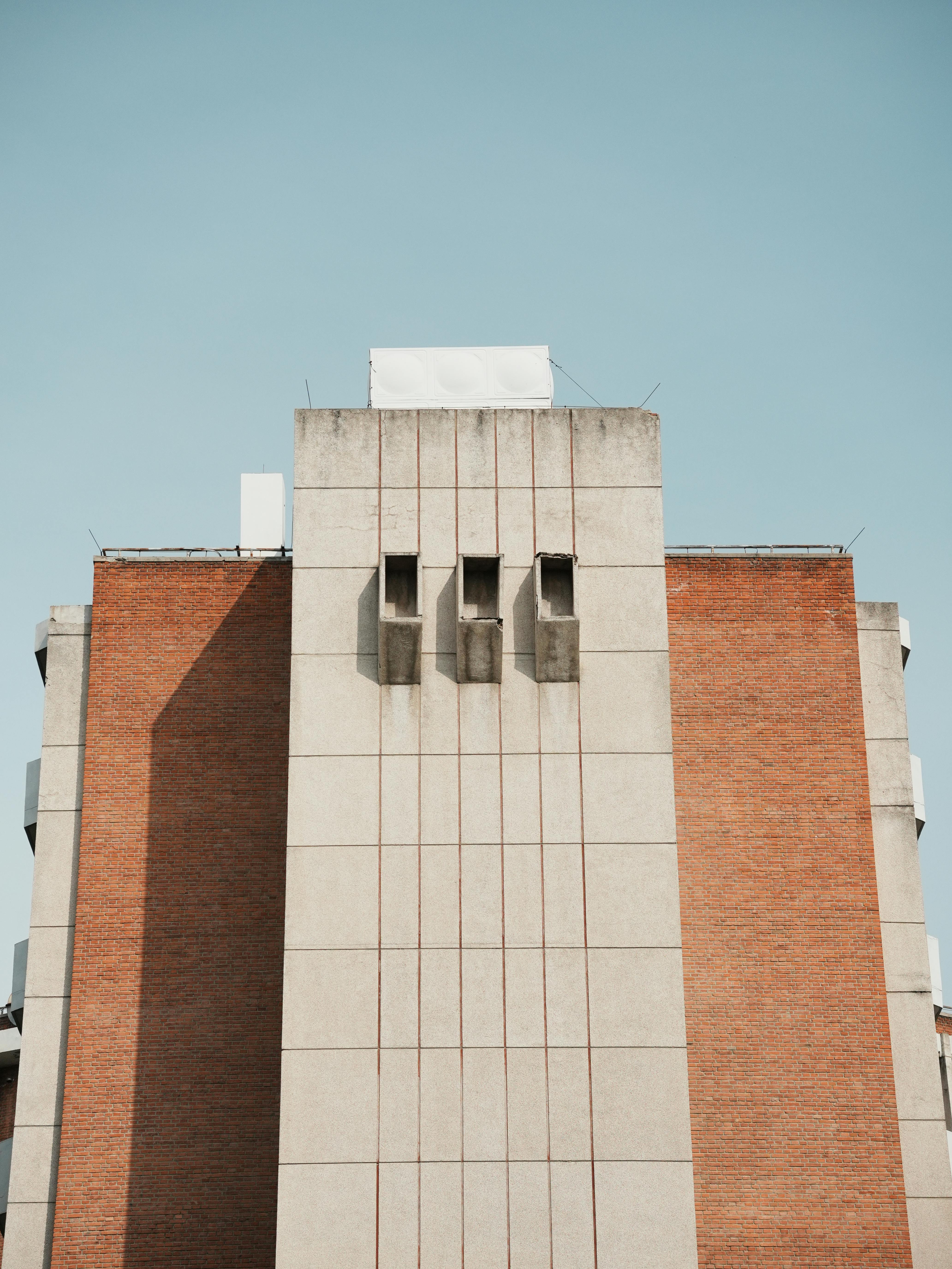 Ücretsiz Açık mavi gökyüzüne karşı tuğla ve beton tasarımlı modern mimari bir binanın ön görünümü. Stok Fotoğraflar